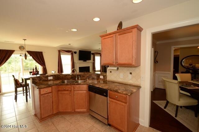 kitchen featuring kitchen peninsula, sink, pendant lighting, dark stone countertops, and dishwasher