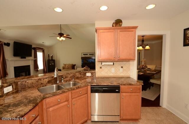 kitchen featuring lofted ceiling, ceiling fan with notable chandelier, sink, stainless steel dishwasher, and tasteful backsplash