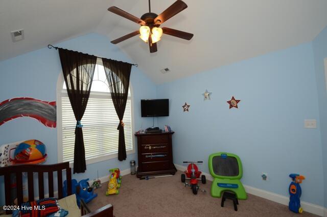 carpeted bedroom with ceiling fan and vaulted ceiling