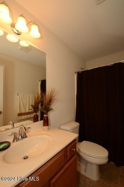 bathroom featuring tile patterned flooring, vanity, and toilet