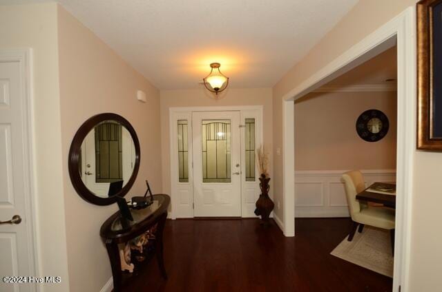 foyer with crown molding and dark wood-type flooring