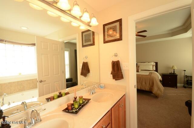 bathroom with ceiling fan, vanity, a healthy amount of sunlight, and ornamental molding