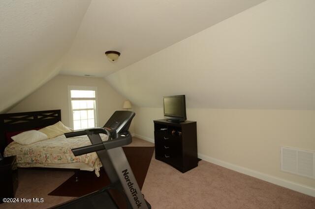 bedroom with carpet floors and vaulted ceiling