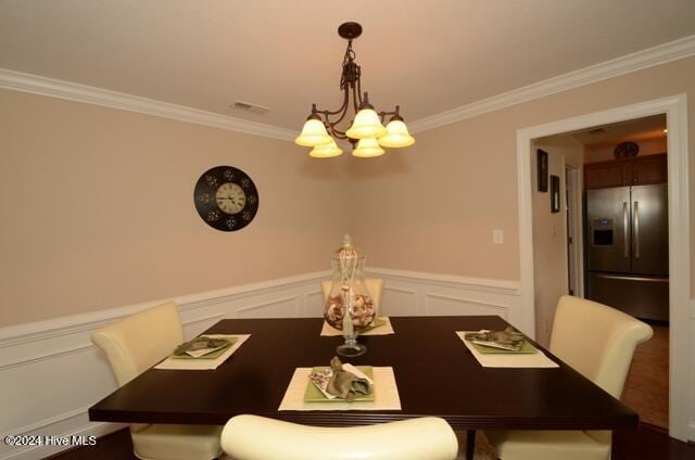 dining area featuring crown molding and an inviting chandelier