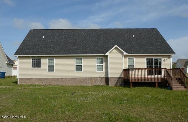 rear view of property with a yard and a deck