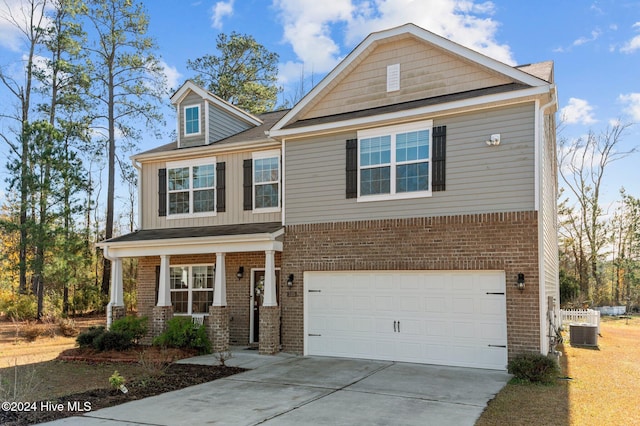 craftsman inspired home featuring central AC unit and a garage