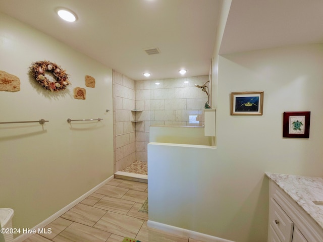 bathroom with vanity and tiled shower