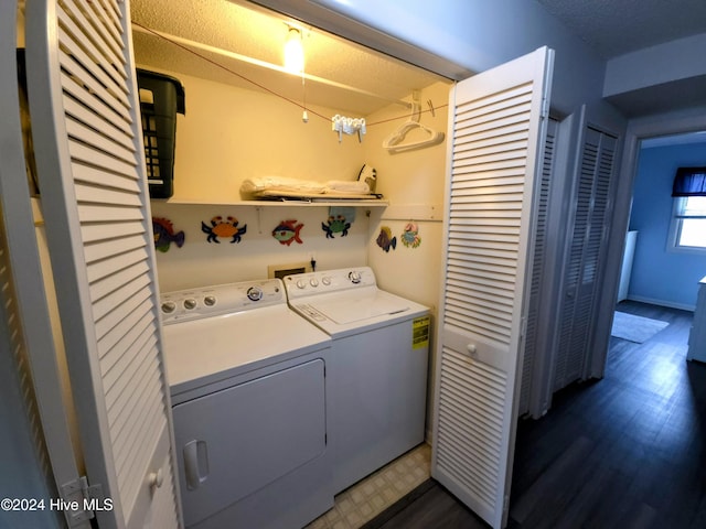 clothes washing area featuring dark hardwood / wood-style flooring, a textured ceiling, and washing machine and clothes dryer