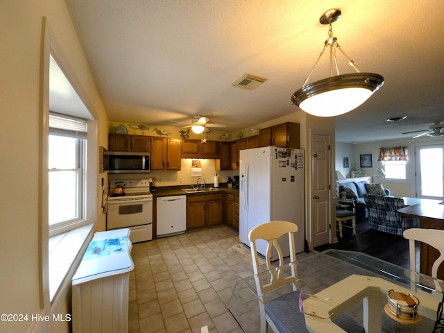 kitchen with a textured ceiling, ceiling fan, sink, and white appliances