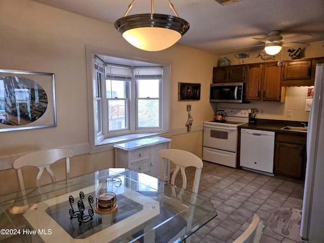 kitchen featuring a textured ceiling, ceiling fan, sink, and white appliances