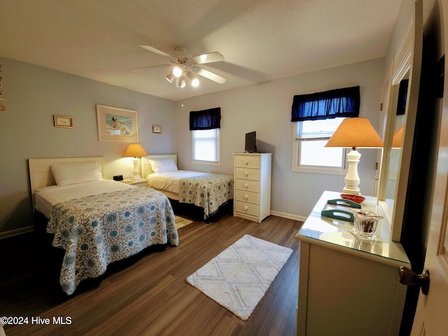 bedroom with multiple windows, ceiling fan, and hardwood / wood-style floors