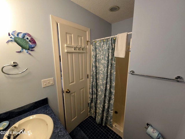 bathroom with a shower with shower curtain, vanity, and a textured ceiling