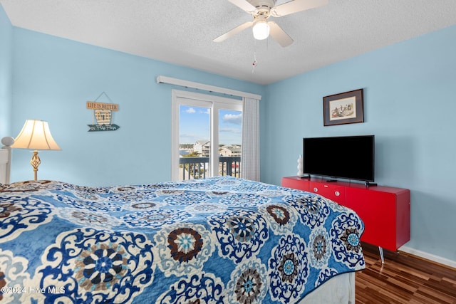 bedroom with ceiling fan, dark hardwood / wood-style floors, a textured ceiling, and access to outside