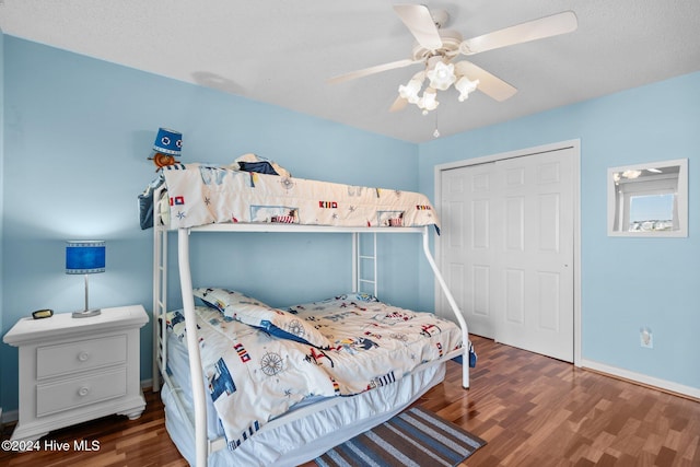 bedroom with a closet, ceiling fan, dark hardwood / wood-style flooring, and a textured ceiling