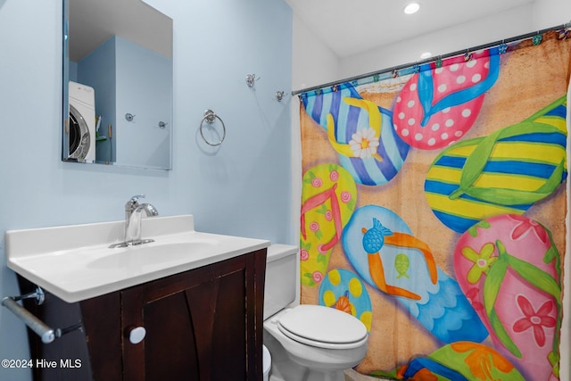 bathroom with vanity, washer / clothes dryer, and toilet