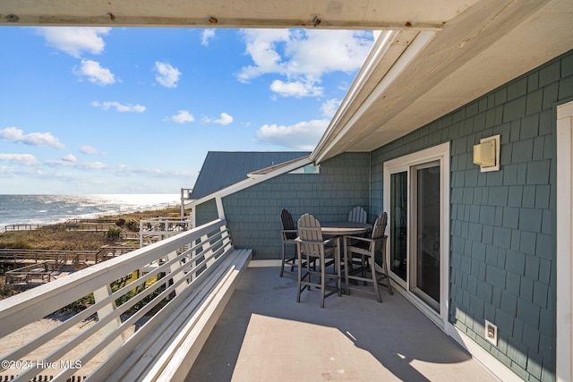 balcony featuring a water view and a beach view