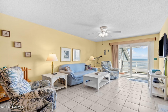 living room featuring light tile patterned floors, a textured ceiling, and ceiling fan