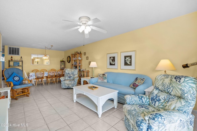 living room featuring ceiling fan with notable chandelier and light tile patterned floors