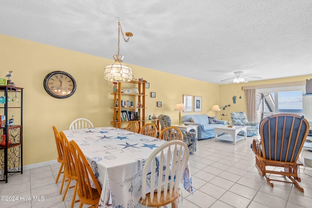 dining space with ceiling fan, light tile patterned flooring, and a textured ceiling