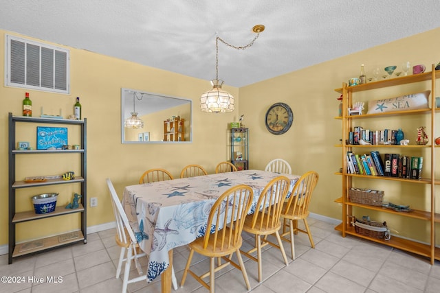 dining space with light tile patterned floors and a textured ceiling