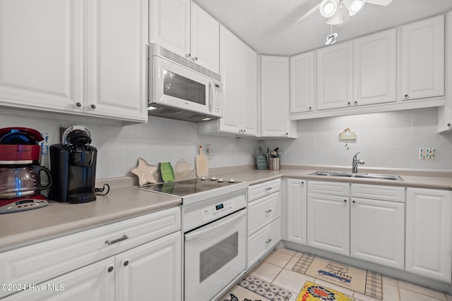 kitchen with white cabinetry, white appliances, sink, and light tile patterned floors