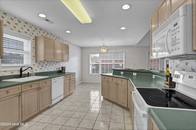 kitchen with light brown cabinets, white appliances, sink, decorative light fixtures, and a chandelier