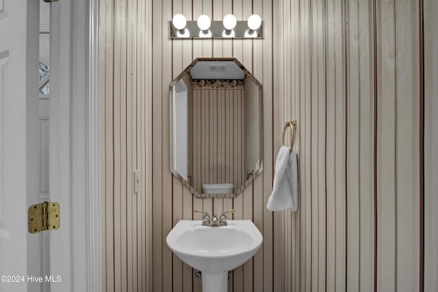 bathroom with wooden walls and sink