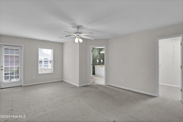 carpeted spare room with ceiling fan