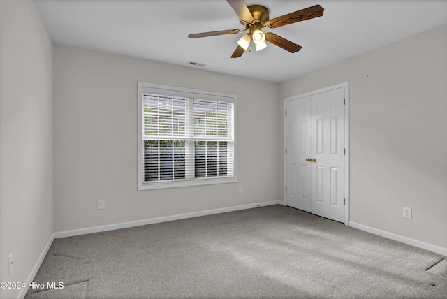 carpeted spare room with ceiling fan