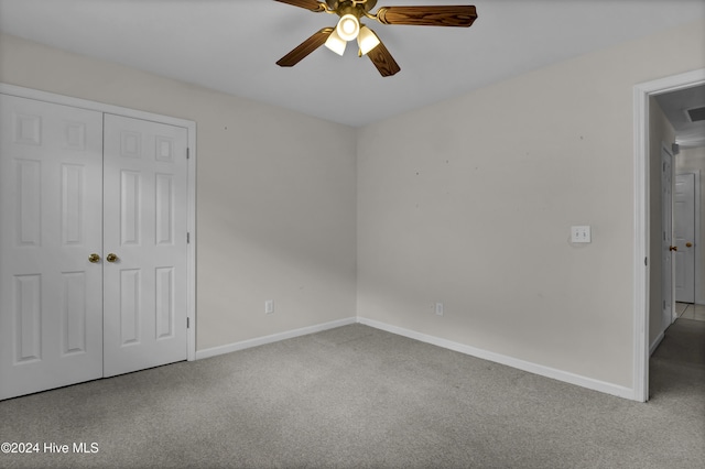 unfurnished bedroom with ceiling fan, a closet, and light colored carpet