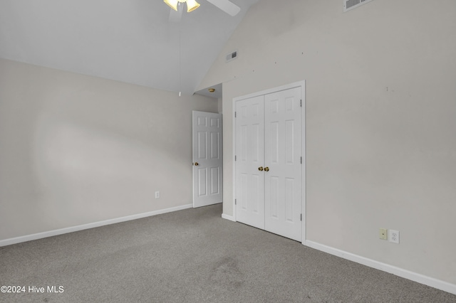 carpeted spare room with ceiling fan and high vaulted ceiling