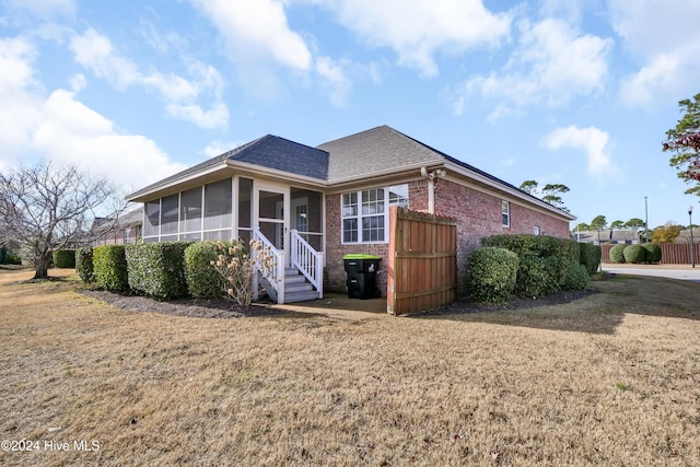 rear view of property with a sunroom and a yard