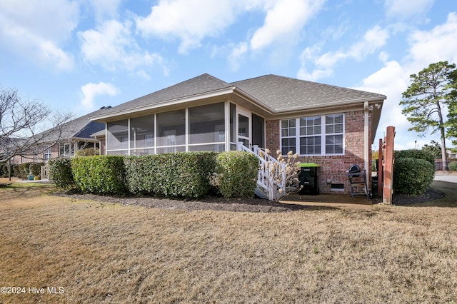 back of house featuring a sunroom and a yard