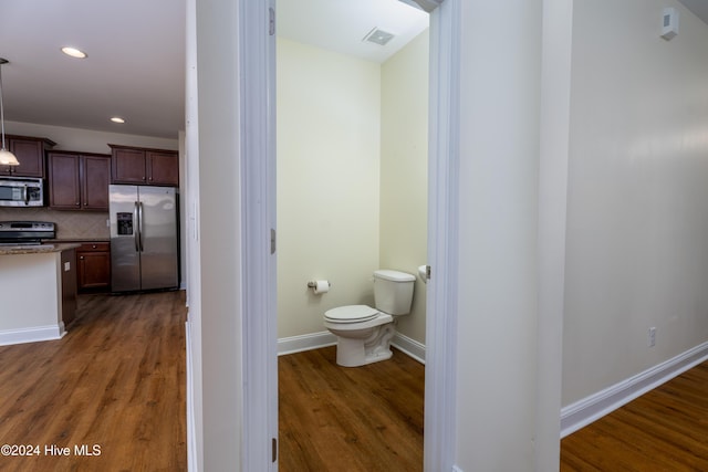 bathroom with tasteful backsplash, hardwood / wood-style floors, and toilet