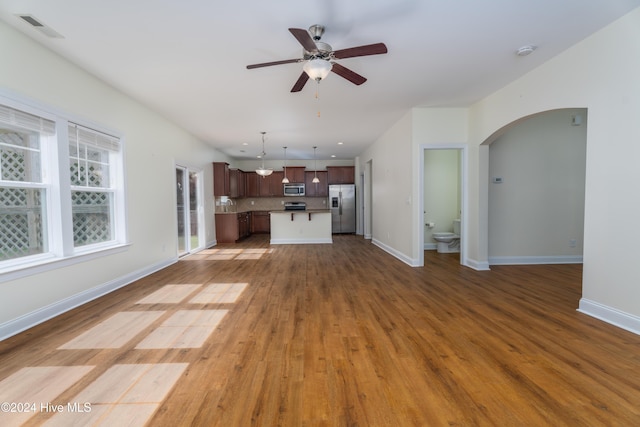 unfurnished living room featuring ceiling fan and wood-type flooring