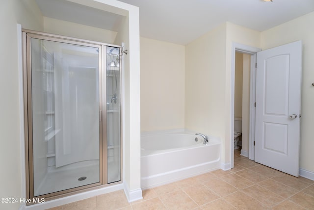 bathroom with tile patterned floors, shower with separate bathtub, and toilet