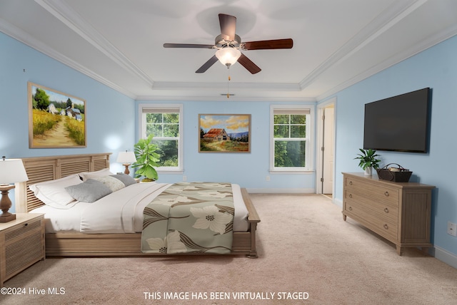 carpeted bedroom featuring a raised ceiling, ceiling fan, and crown molding