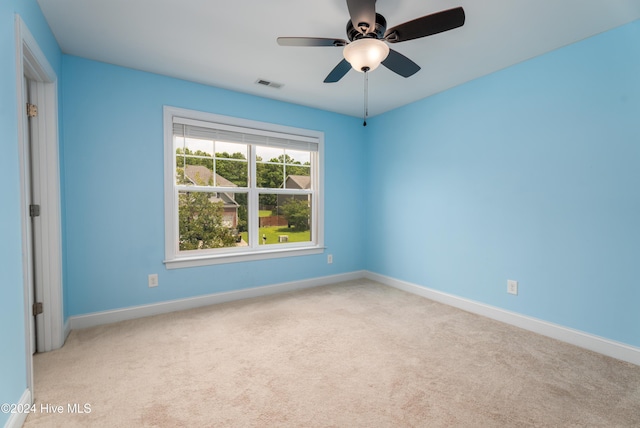 spare room featuring light colored carpet and ceiling fan