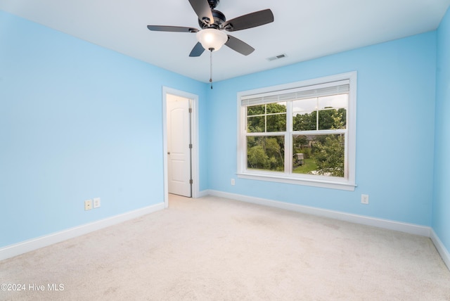 carpeted spare room with ceiling fan