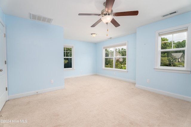 spare room with ceiling fan and light colored carpet