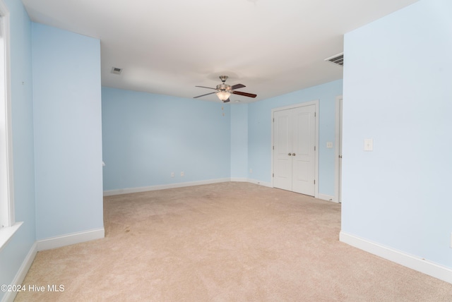 carpeted spare room featuring ceiling fan