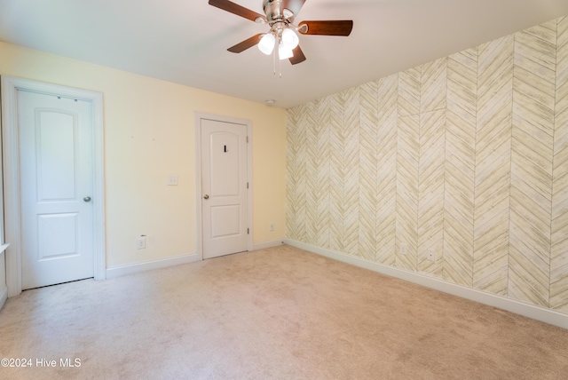 carpeted spare room featuring ceiling fan