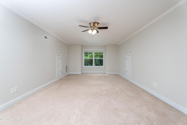 spare room with light colored carpet, ceiling fan, and ornamental molding