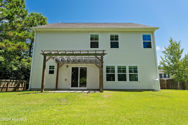 rear view of house featuring a pergola and a lawn