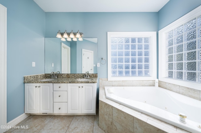 bathroom featuring tile patterned floors, tiled tub, and vanity