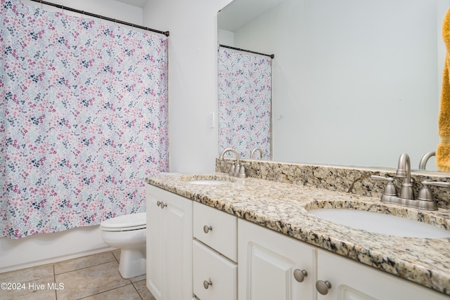 full bathroom featuring tile patterned flooring, vanity, toilet, and shower / tub combo with curtain