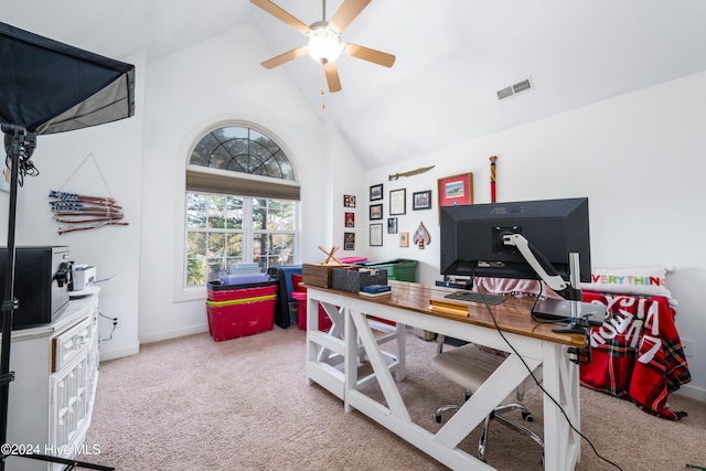 carpeted office space with ceiling fan and high vaulted ceiling