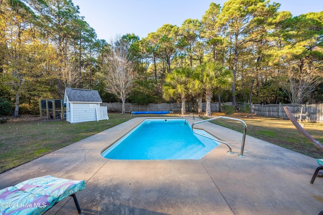 view of pool featuring a patio area, a storage shed, and a lawn