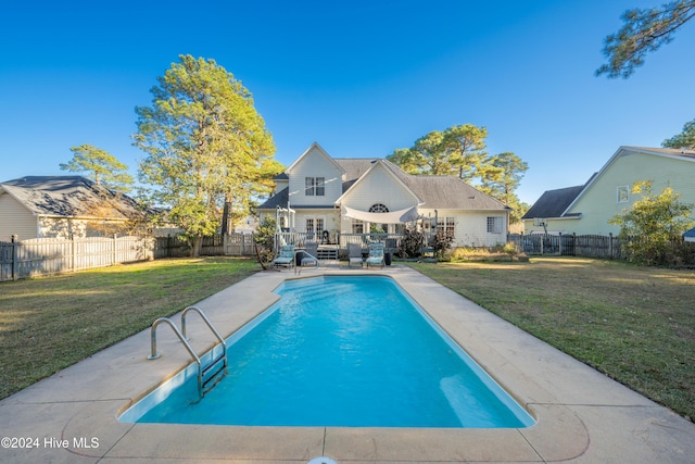 view of pool with a deck and a lawn