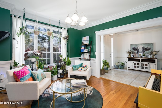 living room featuring light wood-type flooring, an inviting chandelier, and crown molding